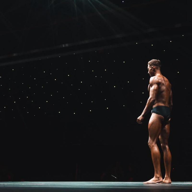 Man standing on a stage with a dark background and spotlight