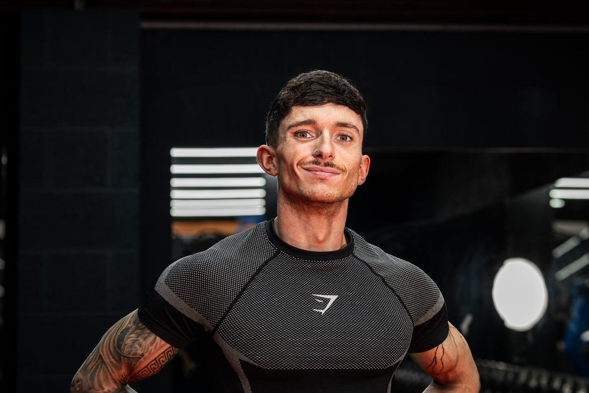 Person wearing a black athletic shirt with a brand logo in an indoor setting