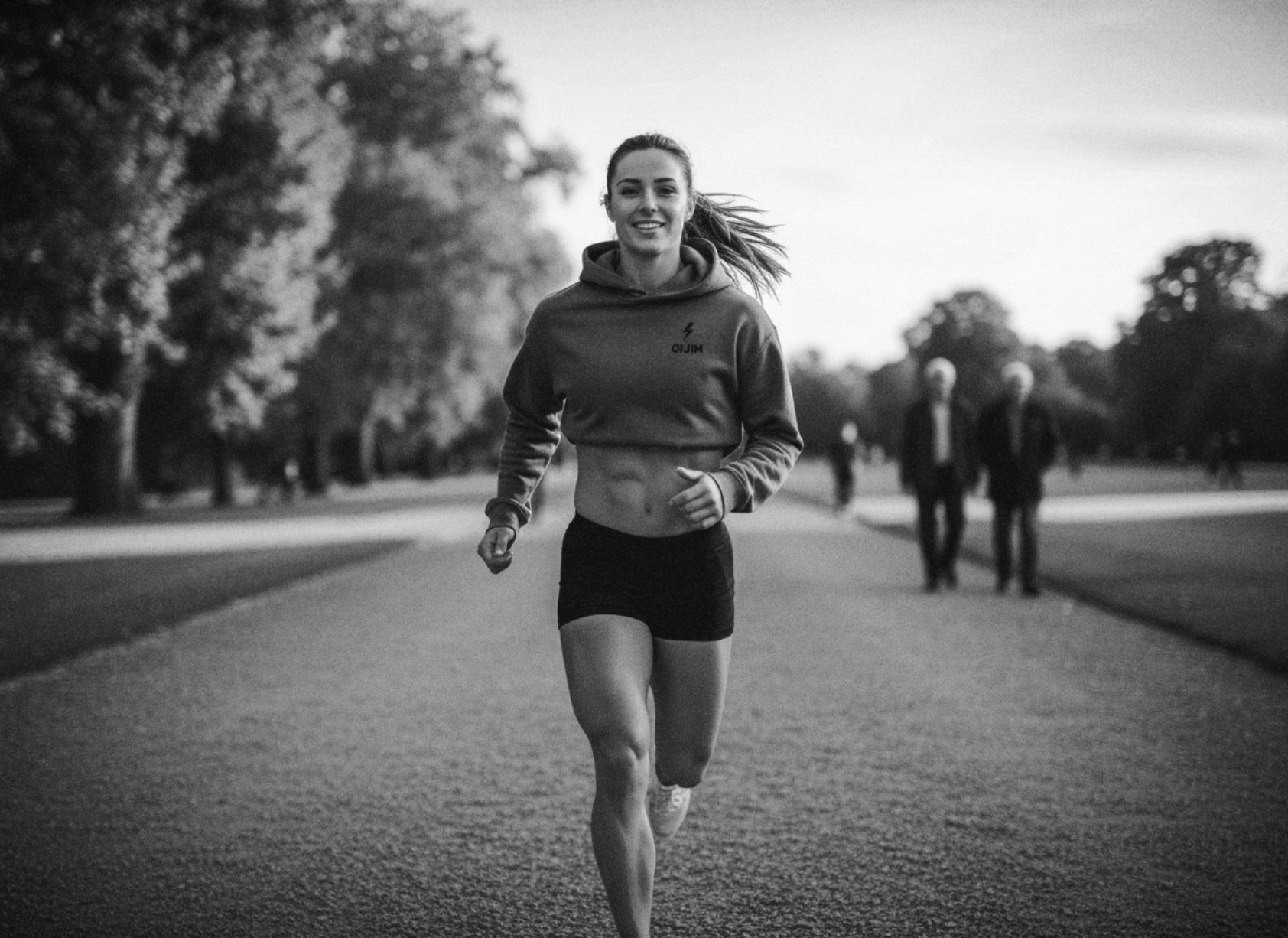 Person running on a path with trees and people in the background